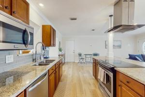 een keuken met een spoelbak en een fornuis bovenste oven bij Bermuda Oasis in Seminole