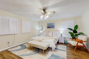 een slaapkamer met een bed en een plafondventilator bij Bermuda Oasis in Seminole