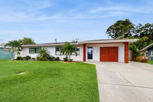 una casa bianca con una porta rossa e un cortile di Bermuda Oasis a Seminole