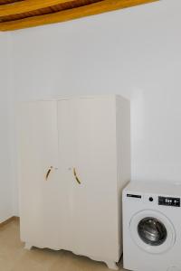 a white laundry room with a washing machine at Ikia Damianou Traditional House in Archangelos