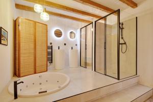 パリにあるPick A Flat's Apartment in Grands boulevards- Rue Cadetの浴槽とガラスのシャワー付きのバスルーム