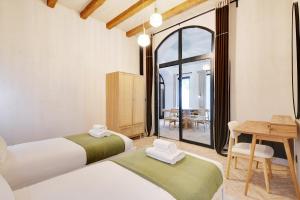 パリにあるPick A Flat's Apartment in Grands boulevards- Rue Cadetのテーブルと机のある部屋にベッドが2つある