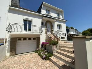 Una casa blanca con garaje y unas escaleras. en Maison Saint Marc sur Mer, en Saint-Nazaire