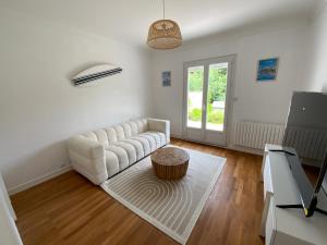Una sala de estar con un sofá blanco y una mesa. en Maison Saint Marc sur Mer, en Saint-Nazaire