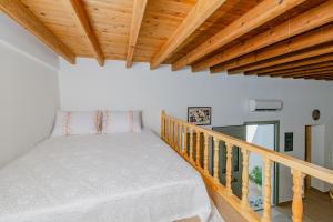 a bedroom with a bed on a staircase with wooden ceilings at Ikia Damianou Traditional House in Archangelos