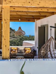 a porch with a couch and a swing at Apademia Skyros Luxury Residences in Skiros