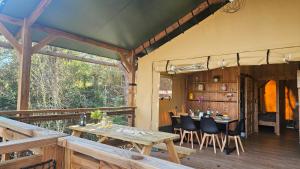 a patio with a table and chairs on a deck at Camping maeva Respire La Serre in Aigues-Vives