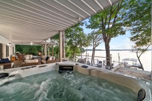 an outdoor hot tub with a view of the water at Bluebird Sanctuary w Stunning Sunset Views Sleeps 28 in Big Sandy