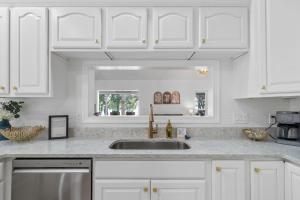 a kitchen with white cabinets and a sink at Bluebird Sanctuary w Stunning Sunset Views Sleeps 28 in Big Sandy