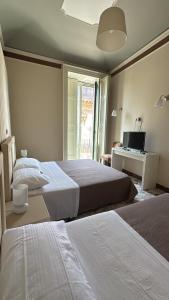 1 dormitorio con 2 camas y escritorio con ordenador en Incanto d'Aci, en Acireale