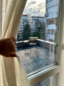 a person looking out of a window at a balcony at Гнездото l The Nest in Burgas City