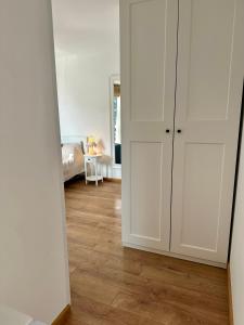 a room with white cabinets and a wooden floor at Гнездото l The Nest in Burgas City +1 photo