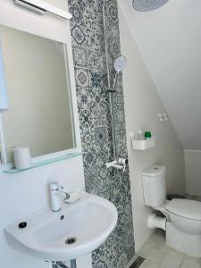a bathroom with a sink and a toilet and a mirror at Гнездото l The Nest in Burgas City