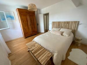 Un dormitorio con una cama grande con cabecero de madera. en Maison Saint Marc sur Mer, en Saint-Nazaire