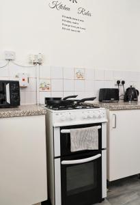 a kitchen with a stove top oven in a kitchen at Kingston Duplex Sleeps 8 Balcony Parking & Wi-Fi in Kingston upon Thames