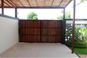 a wooden gate in a building with a fence at Near to The Beach Ayunjani Villa, Bali in Ketewel