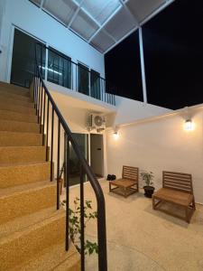 a hallway with two benches and stairs in a building at Laloon Guesthouse in Hat Yai +11 photos