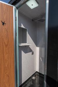 una ducha con puerta de cristal en un baño en Schitterhof CAMPING WEISS, en Spielberg