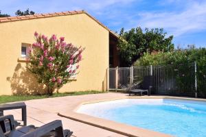a swimming pool in a yard next to a house at Repos et Tranquillité - Super Calme de la campagne - Clim - Grande Piscine Partagée au Sel - Déco cosy tout confort in Montélimar