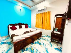 Un dormitorio con una cama con una pared azul. en Nikilan Residency, en Rameswaram 7 fotos más