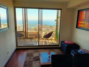 a living room with a large window with a view at Departamento con una hermosa vista al mar in Valparaíso
