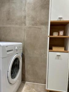 eine Waschmaschine und einen Trockner im Bad mit einer Wand in der Unterkunft Knus kamer bij station Alexander & winkelcentrum in Rotterdam