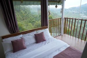 una cama en una habitación con una ventana grande en Magica Mount Sky Rooms, en Kodaikanal