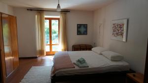 a bedroom with a bed and a large window at The Heritage Home in Novate Mezzola