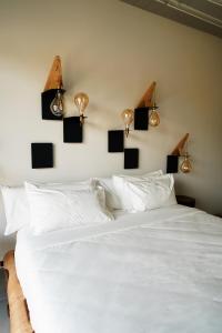 サン・マルチェッロにあるB&B Panevìのベッドルーム1室(壁に照明付きの白いベッド1台付)