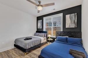 ダーラムにあるLuxe King 3BR Suite Mins to Downtown Durhamのベッド2台と天井ファン付きの寝室