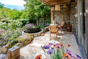 a patio with a fountain and chairs and flowers at Mijn-Habitat in Valkenburg