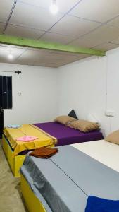 two beds are in a room with a wall at Roxy in Tangalle
