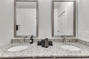 ダーラムにあるLuxe King 2BR Suite Mins to Downtown Durhamの洗面台が2つと鏡が2つあるバスルーム