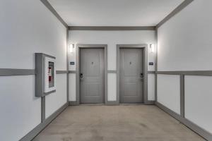 ダーラムにあるLuxe King 2BR Suite Mins to Downtown Durhamの壁面に3つの扉が付いた空間