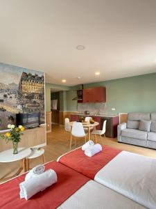 a room with two beds and a living room and a kitchen at Luxury Singular Pensión Estudios Blue in Santiago de Compostela