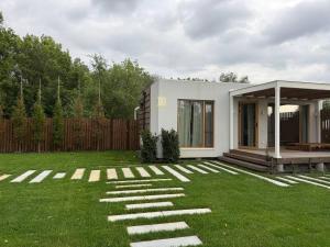 a small white house on a grassy yard at Zarichka in Zachepilovka