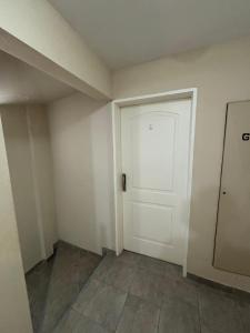 an empty room with a white door and a tile floor at Departamento centrico Avenida Cordoba Edificio Campanarios XIX in Esperanza