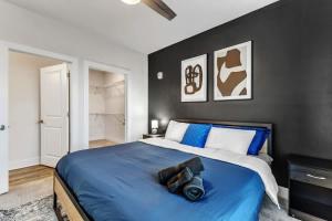 Un dormitorio con una cama azul con una pared negra. en Luxe King 3BR Suite to Downtown Durham, en Durham