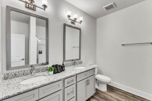 Baño blanco con 2 lavabos y aseo en Luxe King 3BR Suite to Downtown Durham, en Durham 9 fotos más