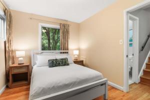 a bedroom with a white bed and a window at Sojourn Beautiful Home with Beach Access & Backyard in Falls Church