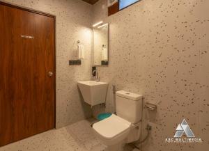 a bathroom with a white toilet and a sink at CASA Resort and Restaurant in Rāmnagar +20 photos