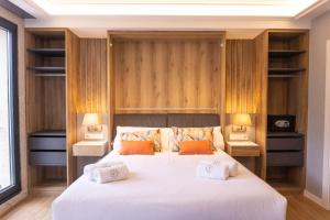 a bedroom with a large white bed with two lamps at Loureira in Pincelo