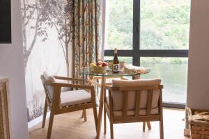 a dining room table with two chairs and a bottle of wine at Loureira in Pincelo