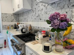 a kitchen with a vase of purple flowers on a counter at Santa Cruz rooms and hospitality 