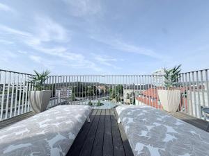a balcony with a bed and two potted plants at designAparts - I - Penthouse mit Dachterrasse in Bayreuth