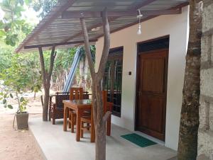 a wooden table and chairs under a wooden umbrella at Wilpattu Buma Lodge in Pahala Maragahawewa +65 photos
