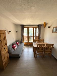 a living room with a couch and a table at Appartement en duplex 5-8 personnes - Les Hauts de Valmeinier A 502 in Valmeinier