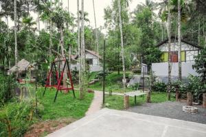 a playground in a park with a swing at Josh Holidays Wayanad in Vaduvanchal