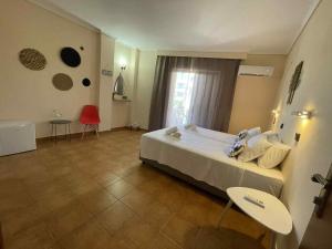 a hotel room with a large bed and a window at COSY Urban Living in Kos Town