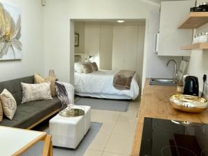 a living room with a couch and a bed at White Waves Beach Apartment in Bloubergstrand